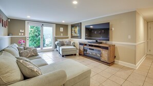 A living room with a sofa set, a fireplace, and a television. - New Fairfield Vacation Rental w/ Lake Views! (New Fairfield)