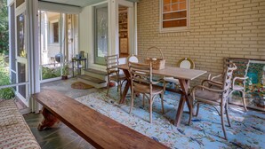 A dining area with a wooden table and chairs, a bench, and a ceiling fan. - Spacious Durham Apartment Near Downtown (Durham)