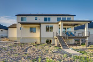 A two-story house with a covered porch and a staircase leading to a balcony. - South Jordan Vacation Rental ~ 17 Mi to Slc! (South Jordan)