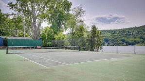 A tennis court with a net, surrounded by a fence and trees. - New Fairfield Vacation Rental w/ Lake Views! (New Fairfield)