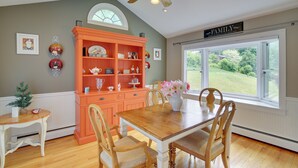 A dining area with a wooden table and chairs, a ceiling fan, and a view through a window. - New Fairfield Vacation Rental w/ Lake Views! (New Fairfield)