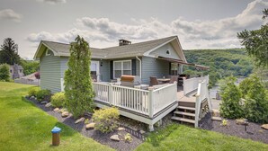 A house with a deck, a barbecue, and a view of a forested area. - New Fairfield Vacation Rental w/ Lake Views! (New Fairfield)