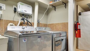 A kitchen with a Maytag washer and dryer, a water heater, and a fire extinguisher. - New Fairfield Vacation Rental w/ Lake Views! (New Fairfield)