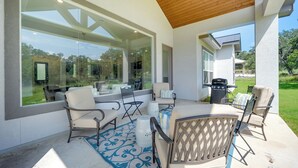 Una terrazza esterna con tavolo e sedie, un barbecue e vista sul paesaggio circostante.