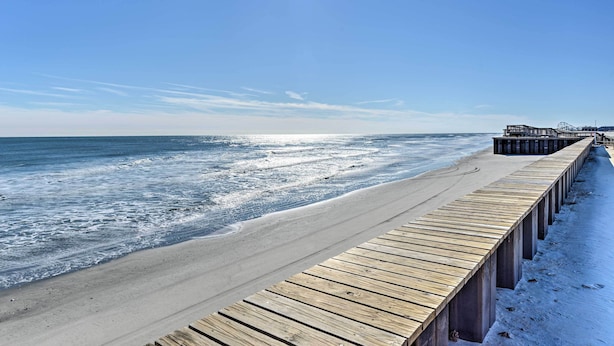 A wooden pier extending into the ocean with a clear sky above. - Beachfront Fourth-floor Condo w/ Community Pool! (North Wildwood)
