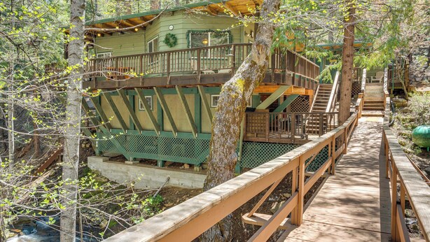 Une cabane en bois dotée d’une terrasse et d’un escalier menant à un balcon.