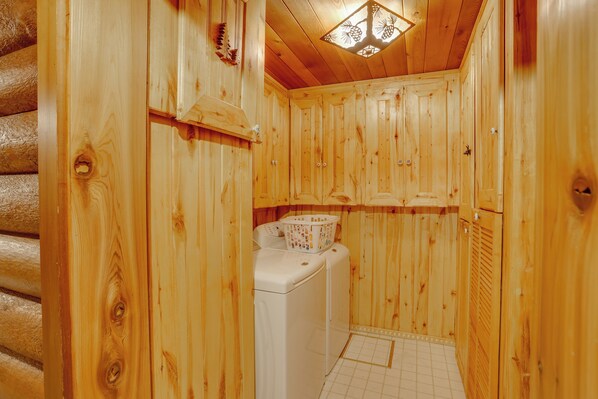 Un interior de madera con una lavadora y una cesta de ropa.