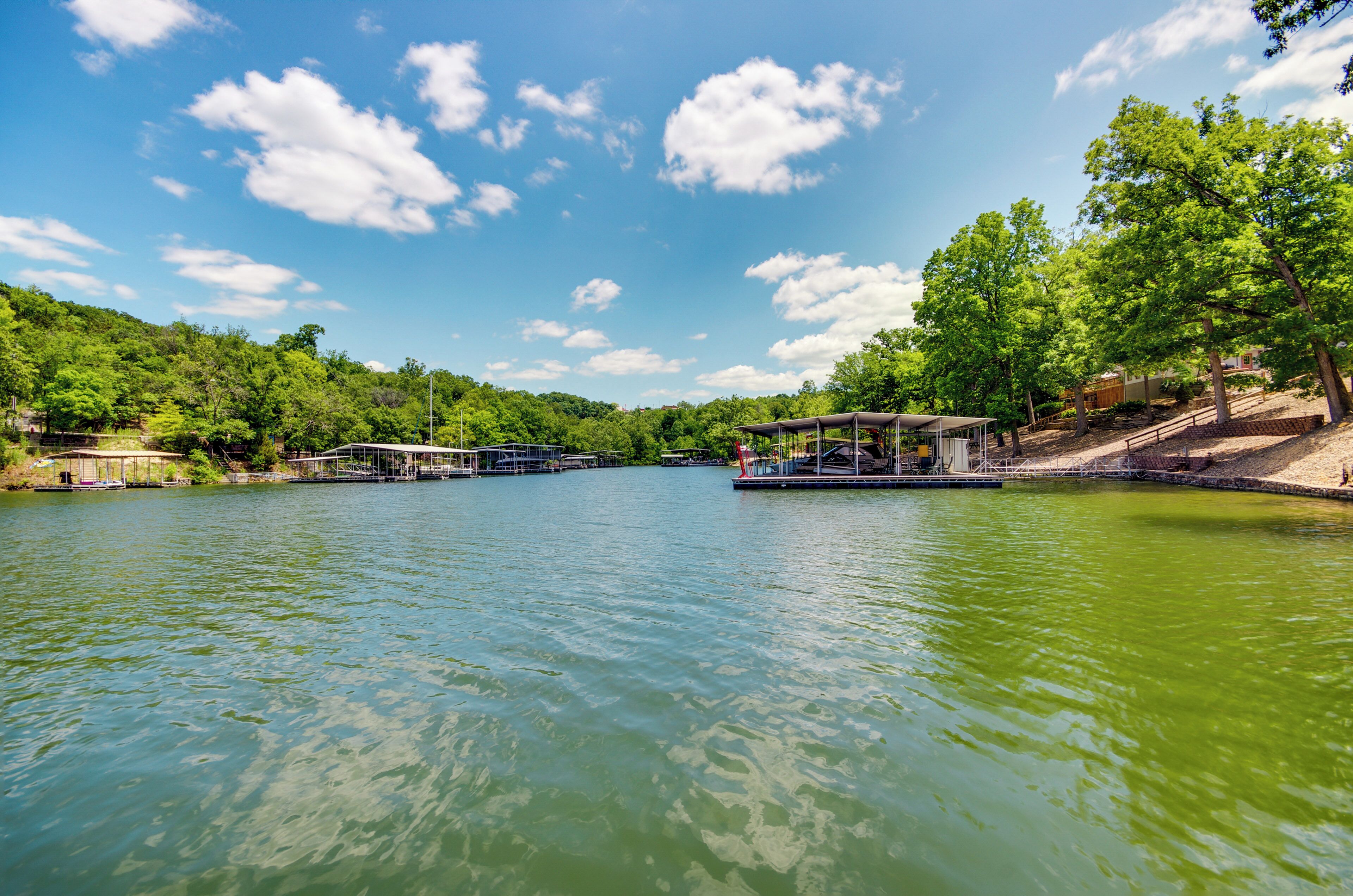 A calm lake with a gazebo and a dock.