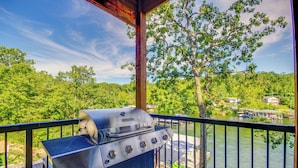 A balcony with a grill overlooking a lake and forest. - Lakefront Osage Beach Retreat w/ Boat Slip! (Osage Beach)