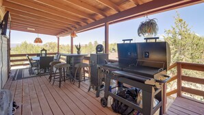 Une terrasse extérieure couverte, équipée d’un barbecue, d’un espace salon et d’un ventilateur.