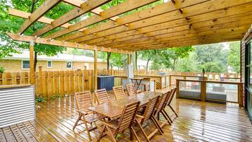 Enjoy meals and gatherings in this spacious outdoor dining area with a sturdy pergola and comfortable seating.