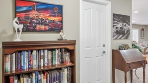 A room with a bookshelf, a door, and two paintings.
