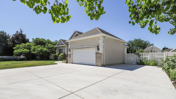 A residential driveway leading to a garage with a white garage door.