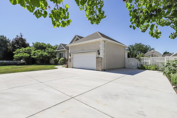 A residential driveway leading to a garage with a white garage door. - Secret Garden Retreat Private Patio Kitchen (American Fork)