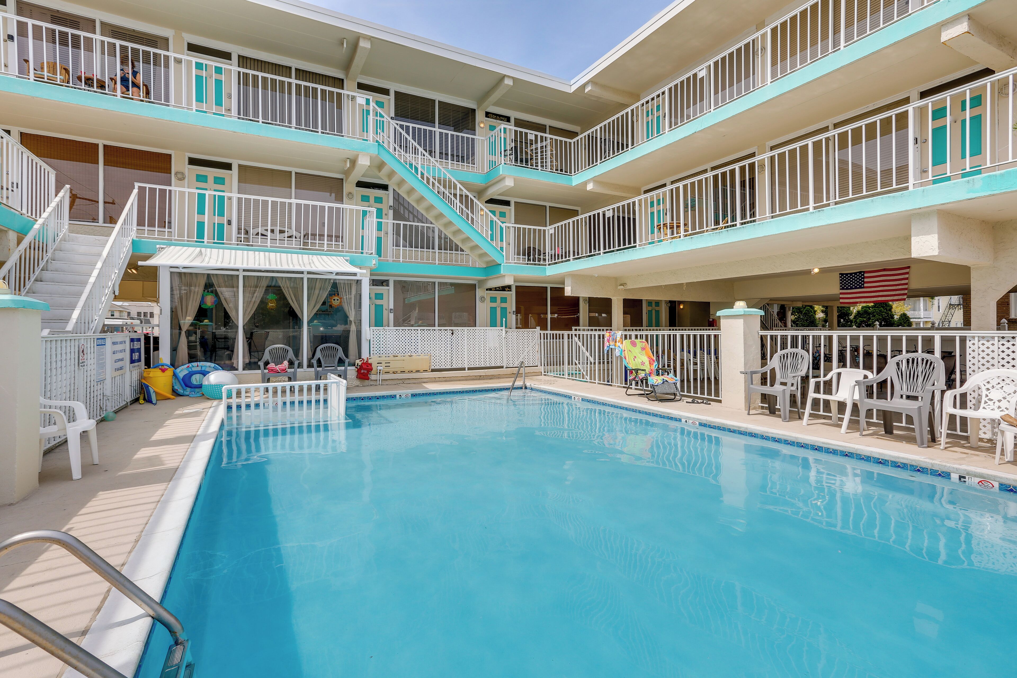 Ein Mehrstöckiges Hotel mit Schwimmbad, Außenbereich und Blick auf die amerikanische Flagge.