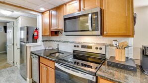 A kitchen with wooden cabinets, stainless steel appliances, and a granite countertop. - Wildwood Condo w/ Community Pool: Walk to Beach! (Wildwood)