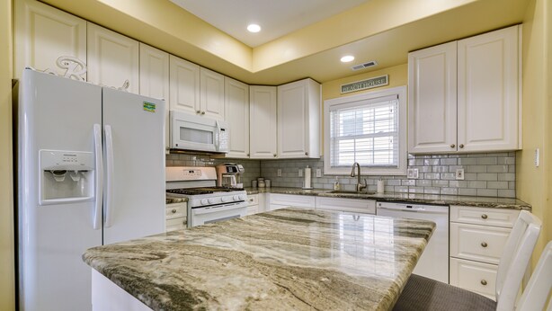 A kitchen with white cabinets, a granite countertop, a refrigerator, a microwave, and a stove. - North Wildwood Townhome < 1/2 Mi to Beach! (North Wildwood)