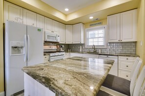 A kitchen with white cabinets, a granite countertop, a refrigerator, a microwave, and a stove. - North Wildwood Townhome < 1/2 Mi to Beach! (North Wildwood)