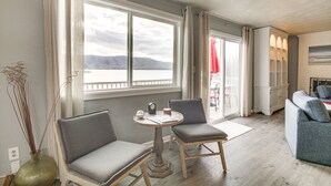 A room with a large window, two chairs, a small table, and a sofa. - Waterfront Smith Mountain Lake Home w/ Dock! (Huddleston)