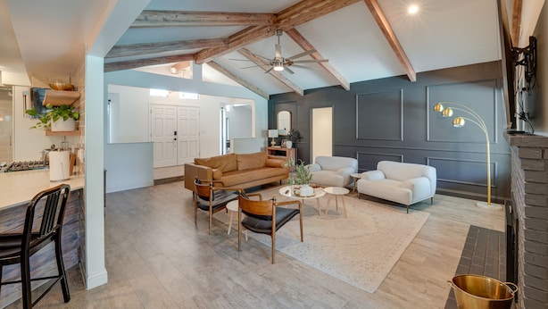 A spacious living area with a high ceiling, exposed wooden beams, a fireplace, and a modern kitchen in the background. - Bakersfield Oasis: Private Pool, Hot Tub & Patio! (Bakersfield)