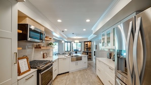 A modern kitchen with stainless steel appliances, white cabinetry, and a central island. - Bakersfield Oasis: Private Pool, Hot Tub & Patio! (Bakersfield)
