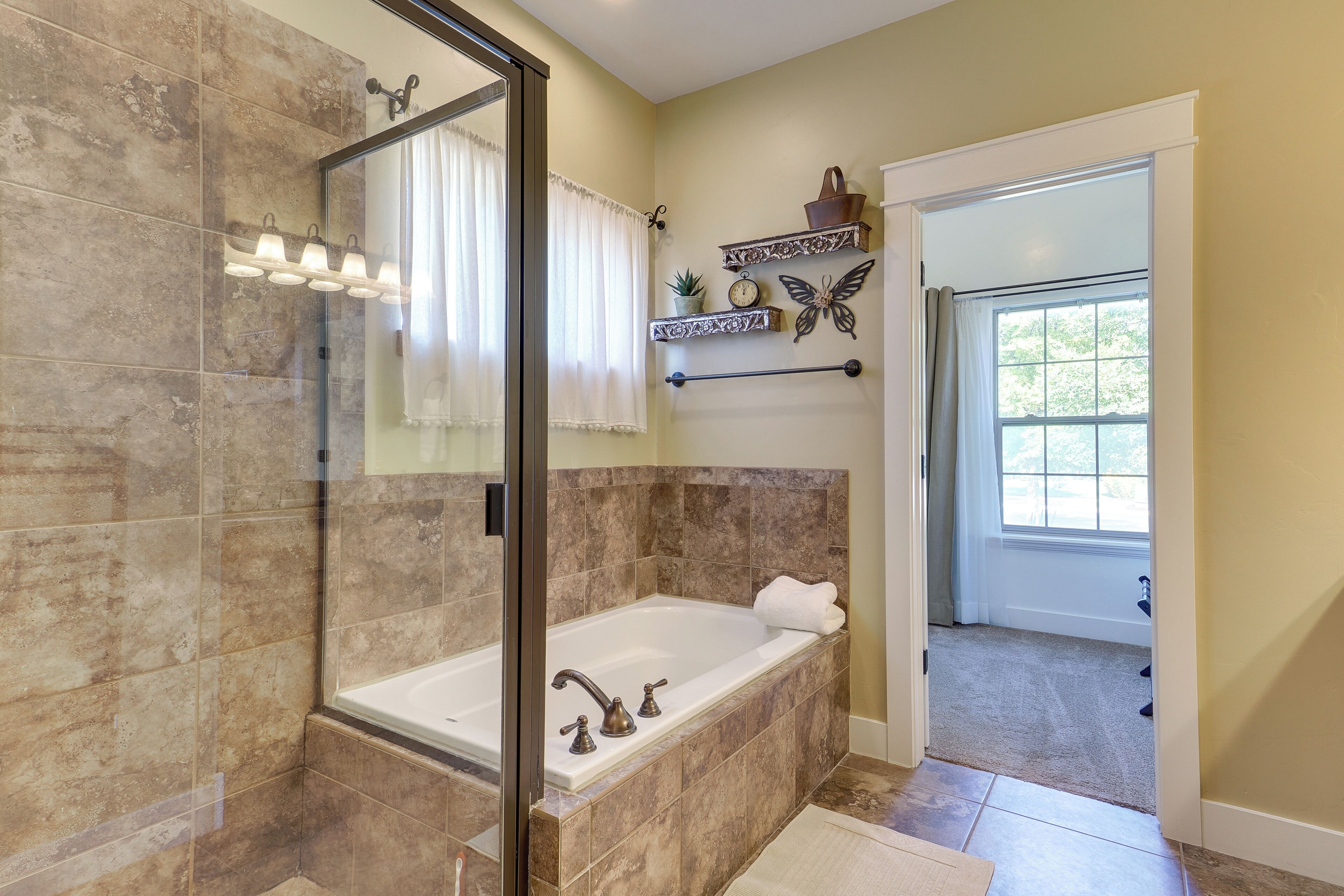 A bathroom with a glass shower enclosure, a freestanding bathtub, and a vanity with a mirror.