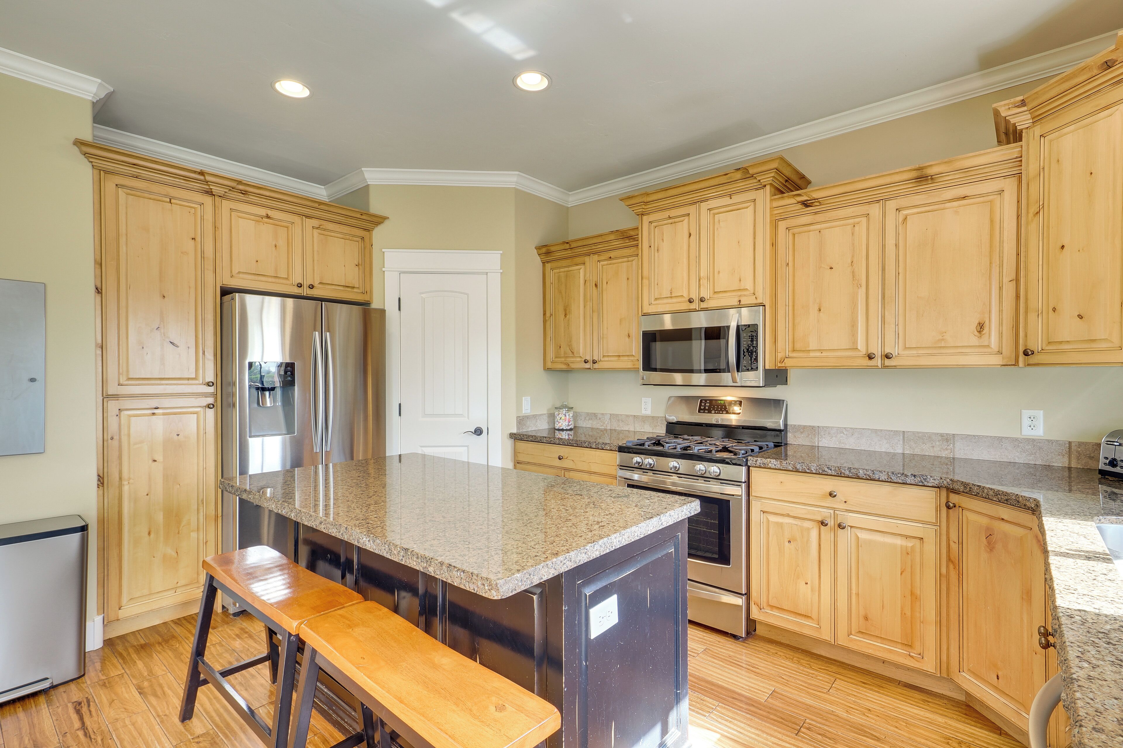 A kitchen with wooden cabinets, stainless steel appliances, and a granite countertop.