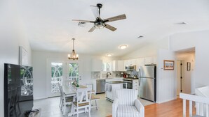 A spacious living area with a dining table, a sofa, and a ceiling fan. - Narragansett Vacation Rental Near River & Beach! (Narragansett)