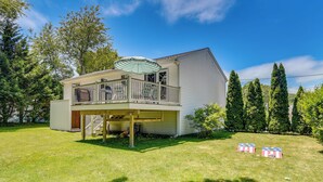 A two-story house with a balcony, a covered patio, and a well-maintained lawn. - Narragansett Vacation Rental Near River & Beach! (Narragansett)