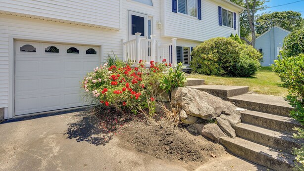 A two-story house with a white exterior, a front porch, and a garage. - Narragansett Vacation Rental Near River & Beach! (Narragansett)