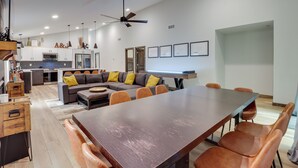 A modern kitchen with white cabinets, a built-in oven, and a microwave. There is a dining area with a large wooden table and orange chairs. - Walk to Water Park: Split-rock Resort Home w/ Deck (Lake Harmony)