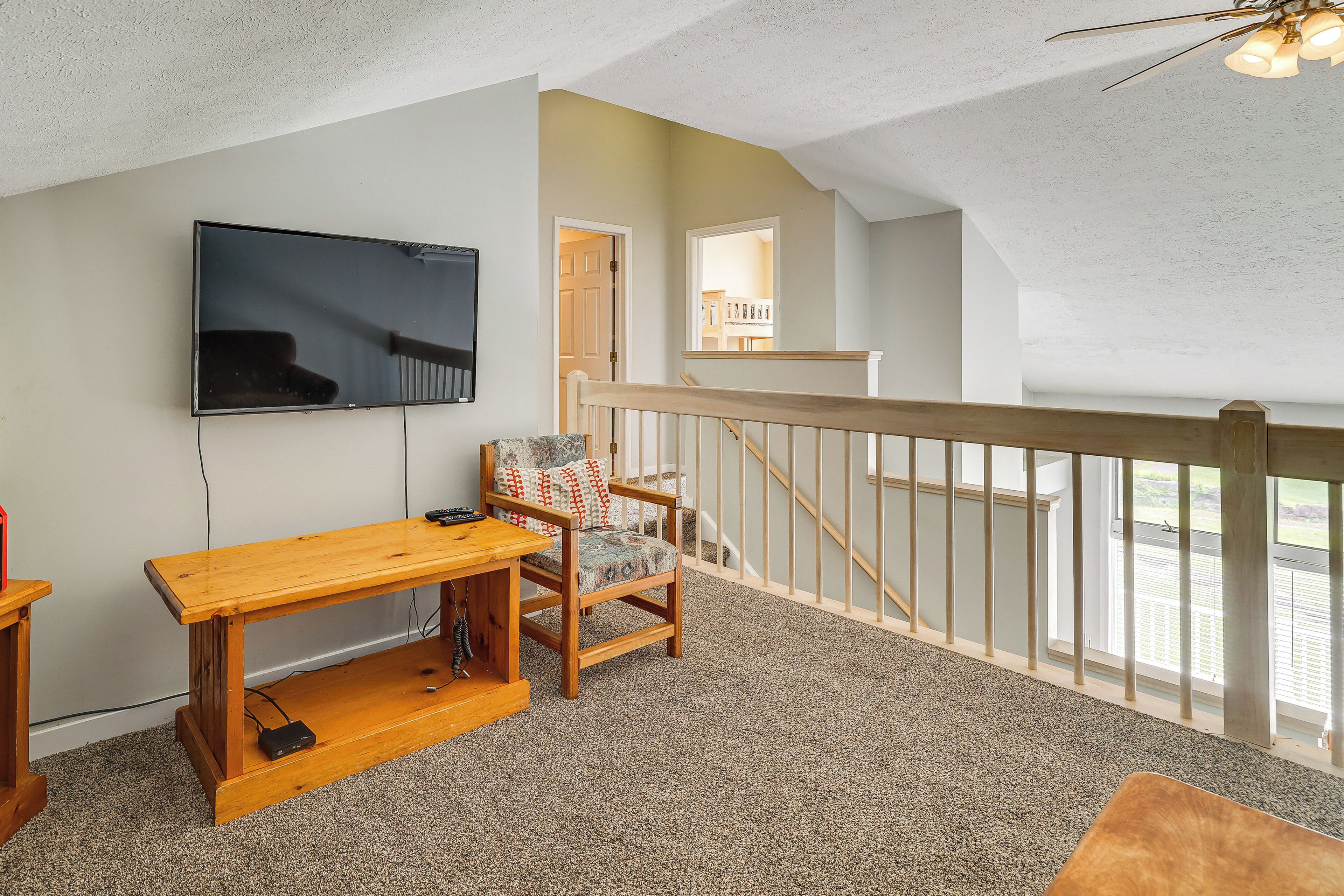 A living room with a wooden TV stand, a chair, and a carpeted floor.