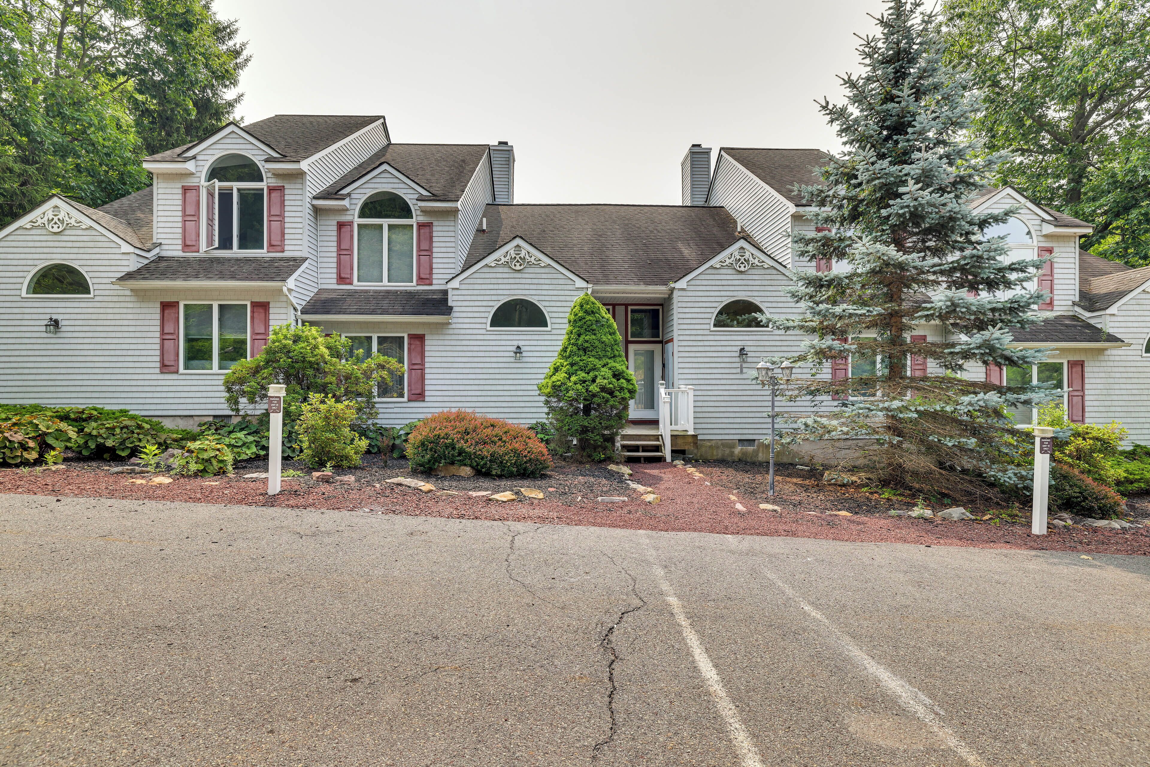 A two-story house with a symmetrical facade, multiple windows, and a central entrance.