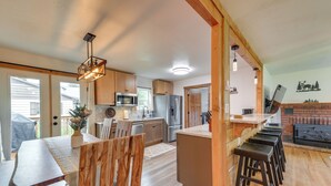 Una cocina amplia con armarios de madera, una isla central y taburetes de bar.
