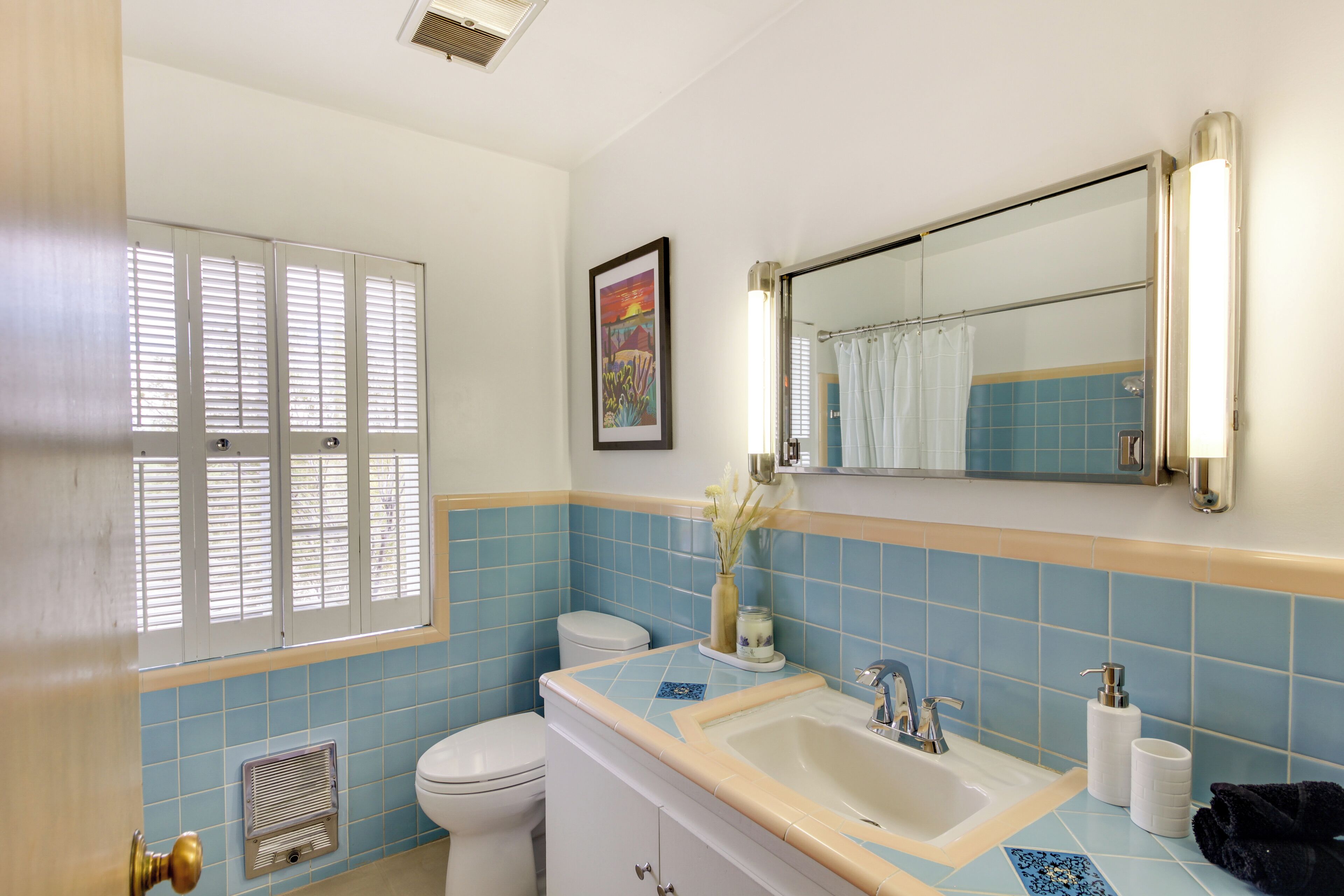 A bathroom with a toilet, sink, and shower area.