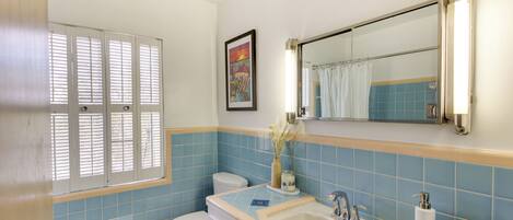 A bathroom with a toilet, sink, and shower area.