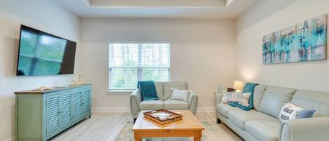 A living room with a television, a sofa, a coffee table, and a cabinet.