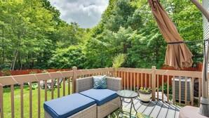A deck with a wicker sofa, a small table, and a potted plant. - Hot Tub, Game Room & Fire Pit: Pocono Summit Home! (Pocono Summit)