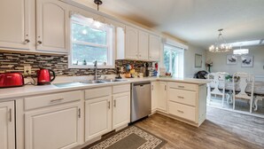 A kitchen with white cabinets, a dishwasher, a red kettle, and a window. - Hot Tub, Game Room & Fire Pit: Pocono Summit Home! (Pocono Summit)