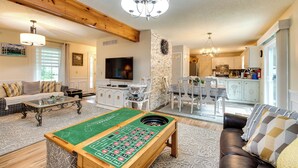 A spacious living room with a pool table, a sofa, a television, and a kitchen in the background. - Hot Tub, Game Room & Fire Pit: Pocono Summit Home! (Pocono Summit)