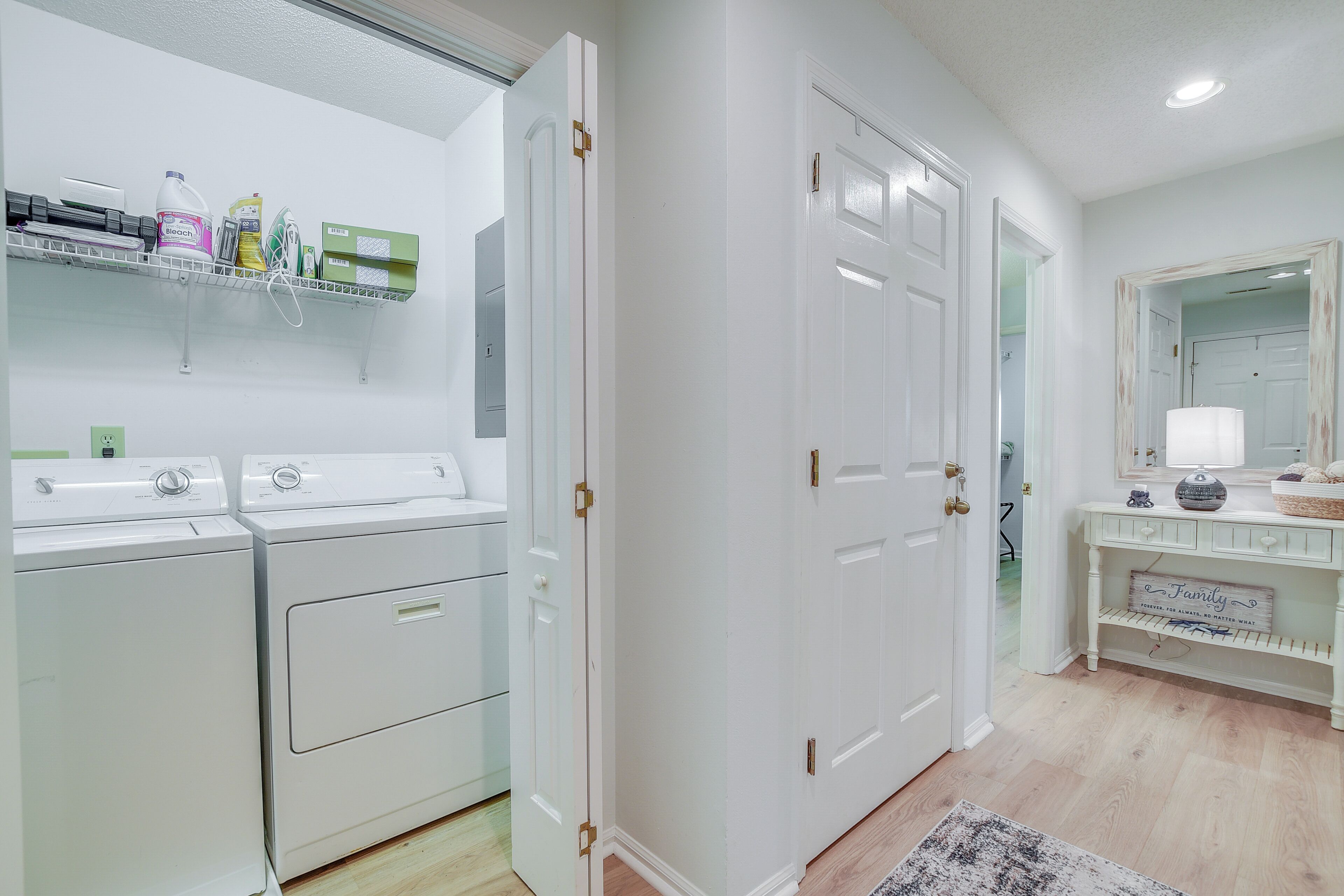 A clean, modern bathroom with white fixtures, a shower area, and a vanity with a mirror and decorative items.