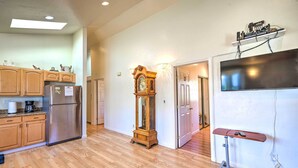 A spacious kitchen with wooden cabinets, a stainless steel refrigerator, and a wooden floor. - San Bruno Vacation Rental - Walk Downtown! (San Bruno)