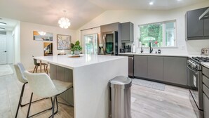 A modern kitchen with a central island, stainless steel appliances, and a view of the outdoors. - Issaquah Retreat Near Lake Sammamish State Park! (Issaquah)