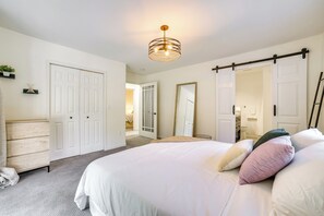 A bedroom with a large bed, white walls, and a ceiling light fixture. - Issaquah Retreat Near Lake Sammamish State Park! (Issaquah)