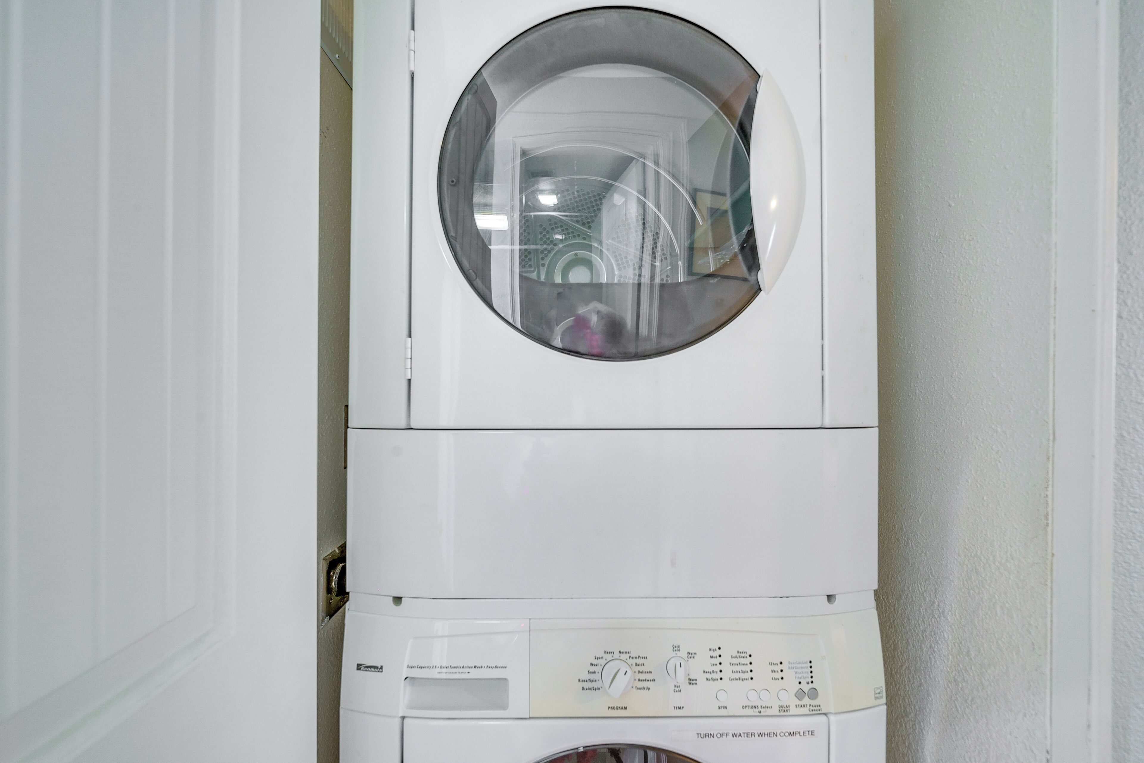 A front-loading washing machine with a control panel and a circular window.