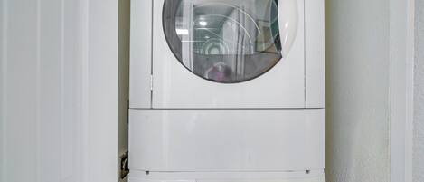 A front-loading washing machine with a control panel and a circular window.