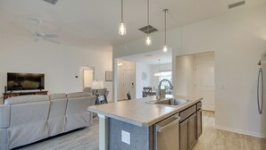 A modern kitchen with a central island, stainless steel appliances, and pendant lighting. - Pool Access: Sleek Home in The Villages w/ Lanai (Wildwood)