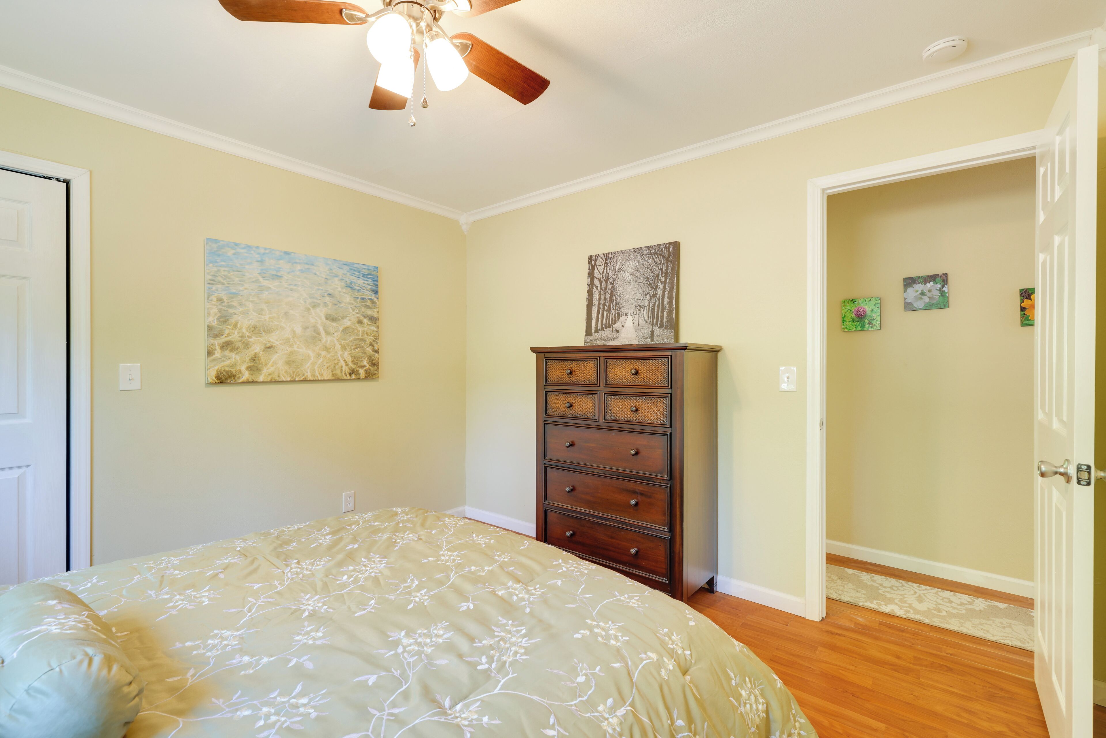 Une chambre à coucher avec un lit, une commode et un ventilateur de plafond.