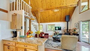 A spacious living area with a wooden ceiling, a kitchen with granite countertops, a fireplace, and a cozy seating area. - Groveland Vacation Rental ~ 26 Miles to Yosemite! (Groveland)