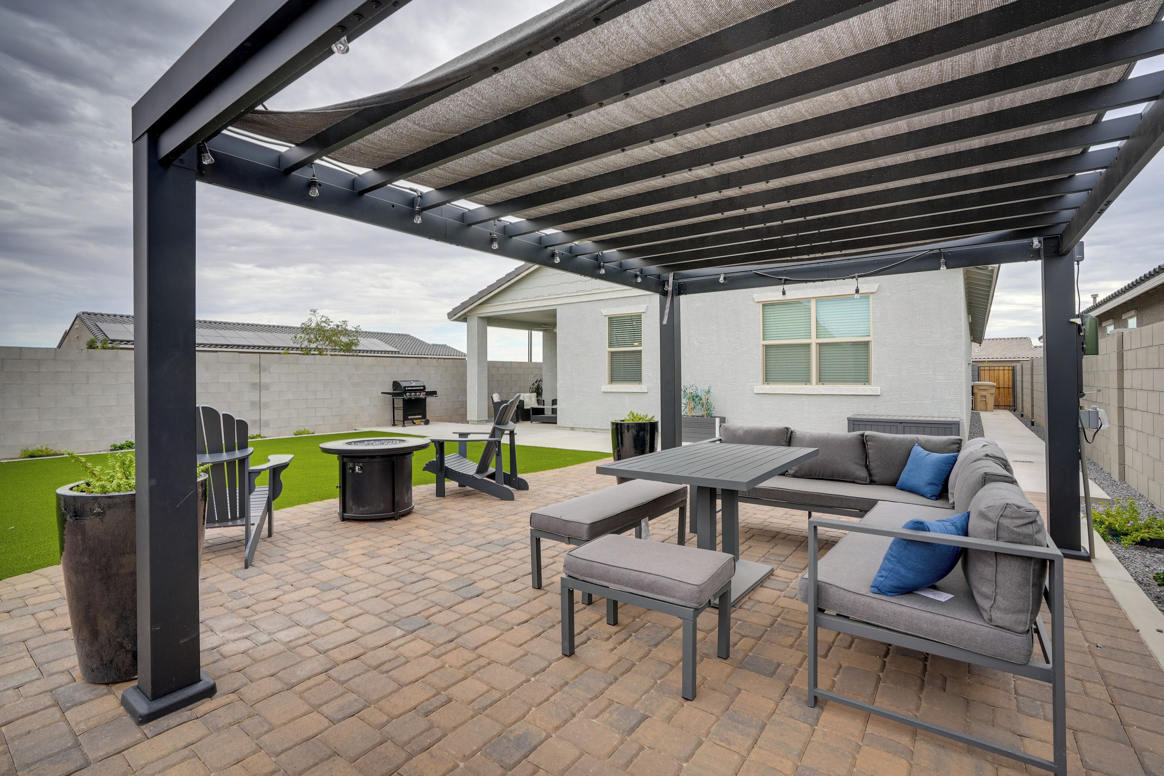 A covered patio area with a table, chairs, and a sofa.